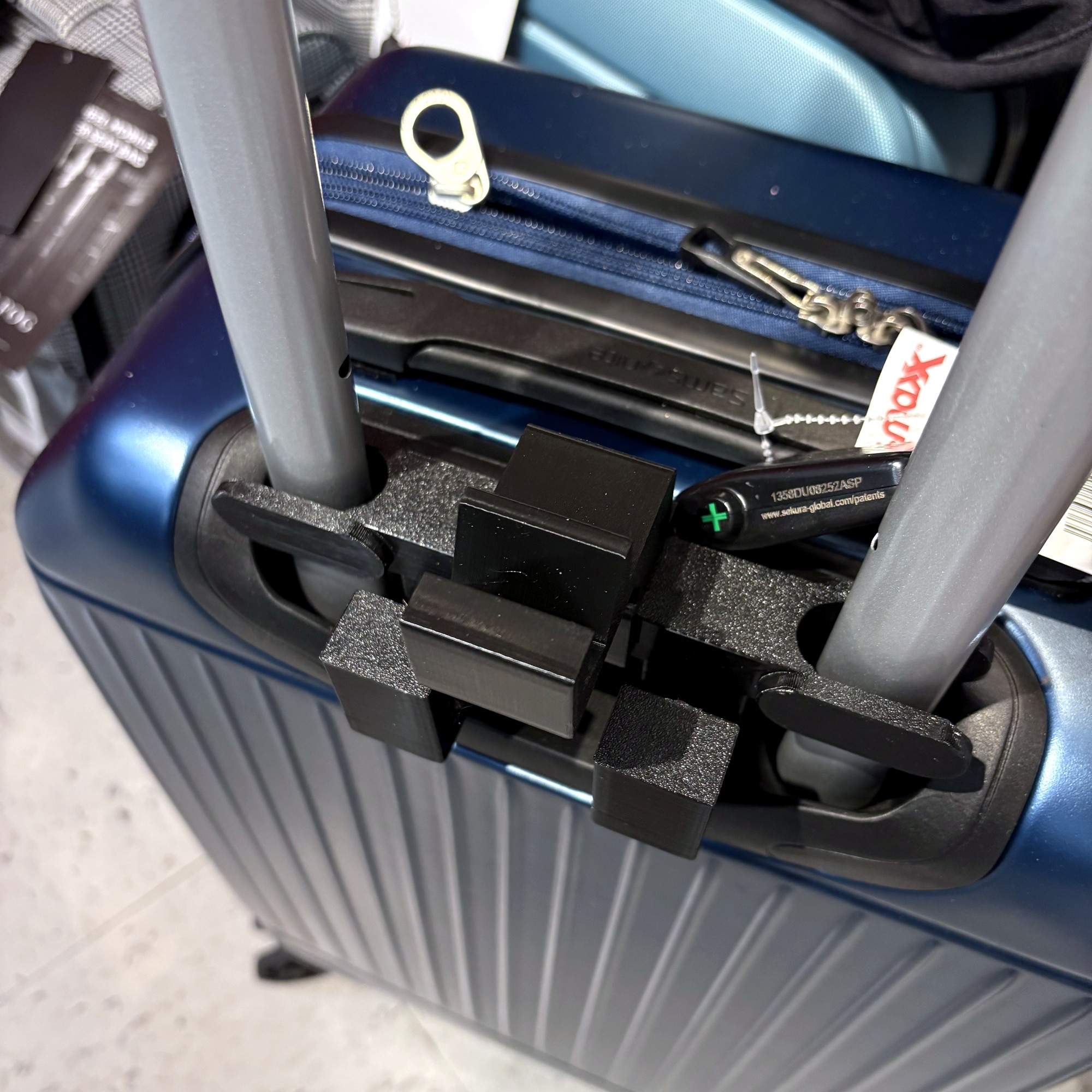 RAILTOTE slid onto a navy Samsonite suitcase handle