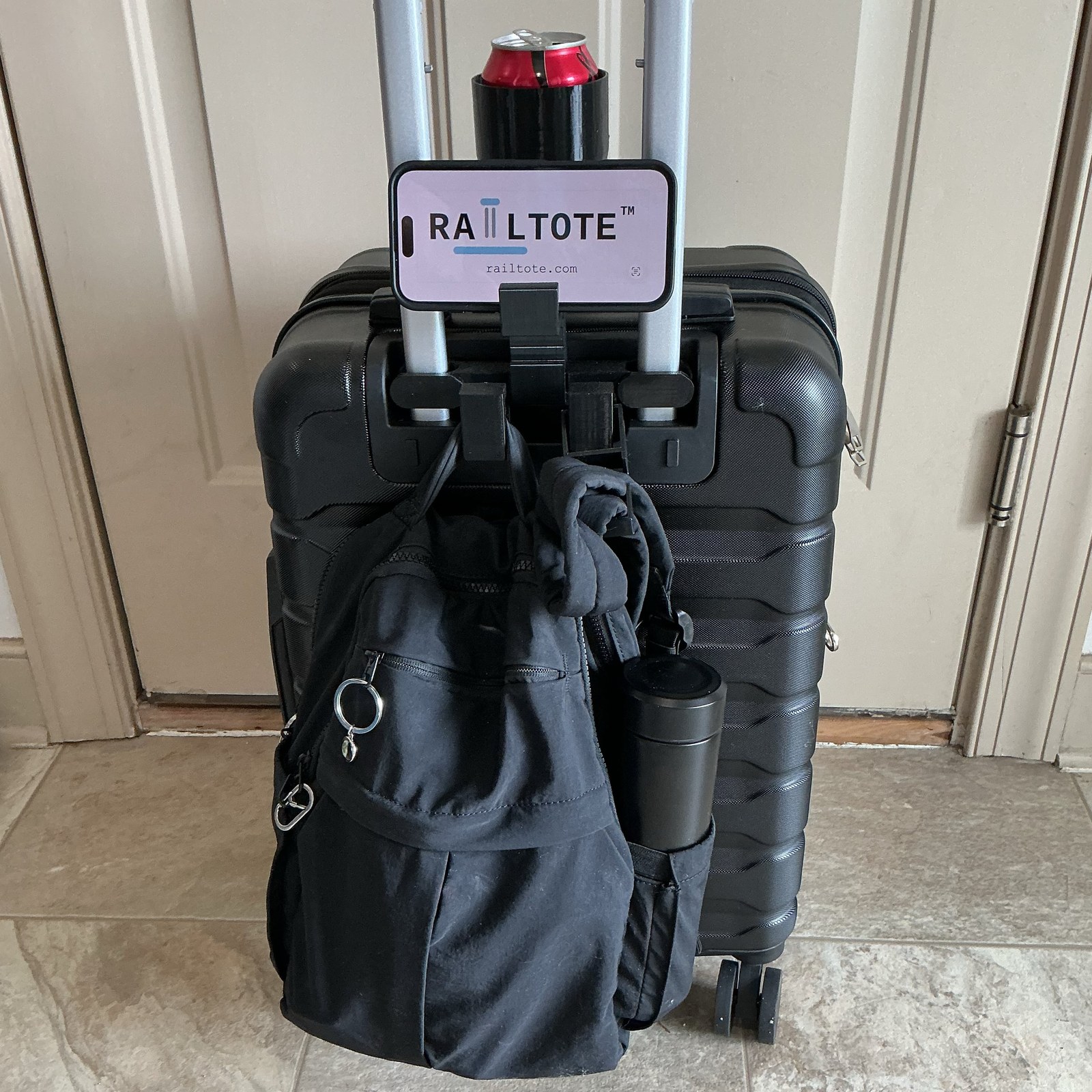 RAILTOTE Cup/Bottle Holder with a drink and a phone propped up, backpack hanging below